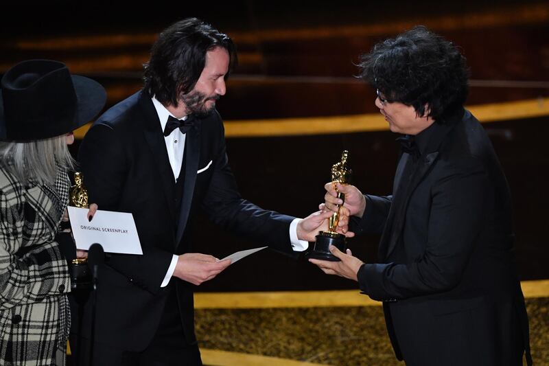 South Korean film director Bong Joon-ho  (R) accepts the award for Best Original Screenplay for "Parasite" from US actor Keanu Reeves (C) and US actress Diane Keaton at the 92nd Academy Awards on Sunday, February 9. AFP
