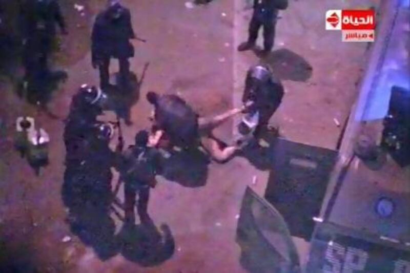 An image grab taken from Al Hayat TV purportedly shows Egyptian police dragging and beating a naked man during clashes with anti-president protesters outside the presidential palace on Friday. Al Hayat TV / AFP