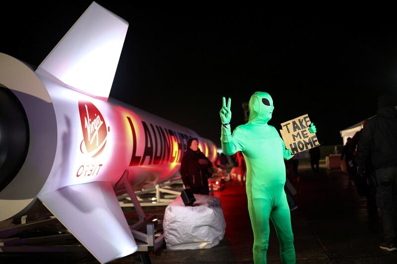 A person wearing an alien costume poses next to a Virgin Orbit rocket at the spaceport in Newquay, Britain, in January. Reuters