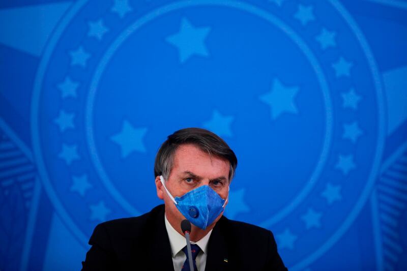(FILES) In this file photo taken on March 20, 2020 Brazil's President Jair Bolsonaro wears a face mask during a press conference on the coronavirus pandemic COVID-19 at the Planalto Palace in Brasilia, Brazil. Brazilian President Jair Bolsonaro announced to CNN Brazil, on July 6, 2020, that he underwent a test on suspicion of coronavirus and that the results will come out tomorrow. / AFP / Sergio LIMA
