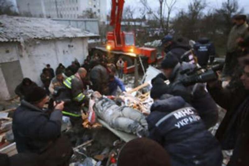 Rescuers carry an injured man from the debris of a shattered five-storey block.