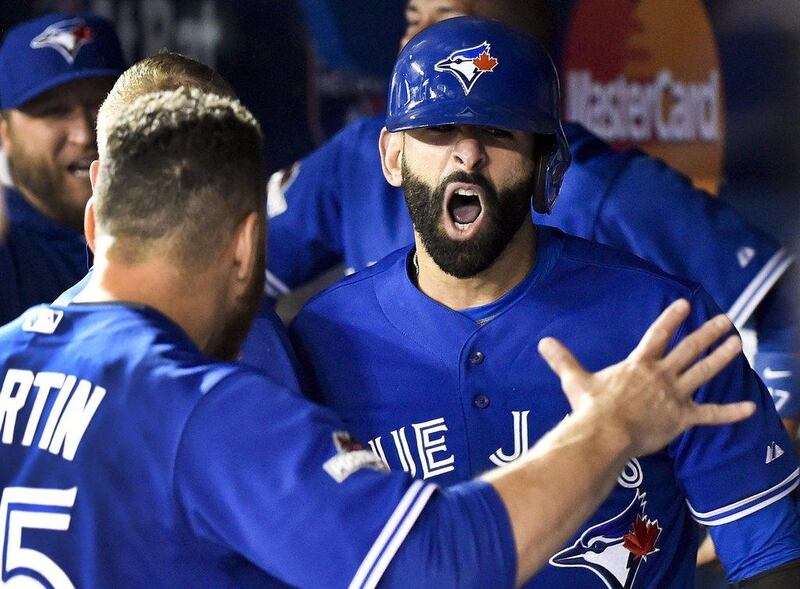 Jose Bautista, right, celebrates his three-run home run with teammate Russell Martin after arriving back in the dugout during Game 5 of the ALDS on Wednesday night. Nathan Denette / The Canadian Press / AP
