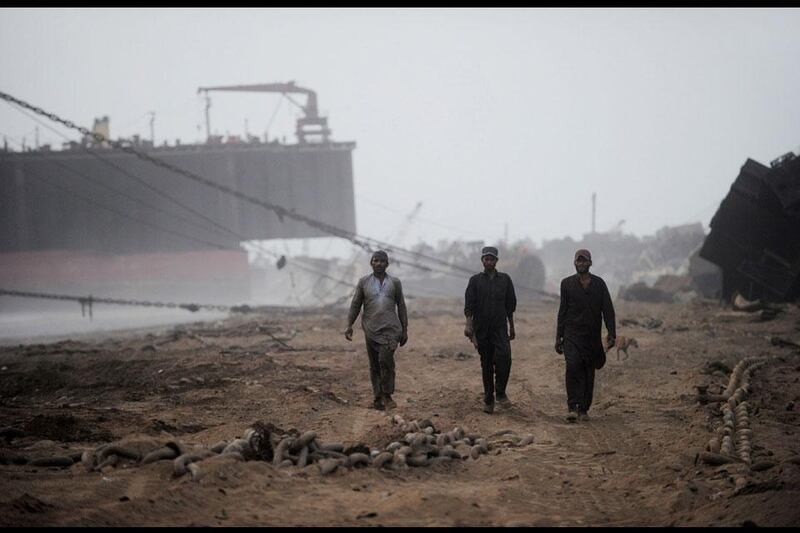 End of another hard day: workers walk away from the shipyard and make their way back to the shacks they call home.
