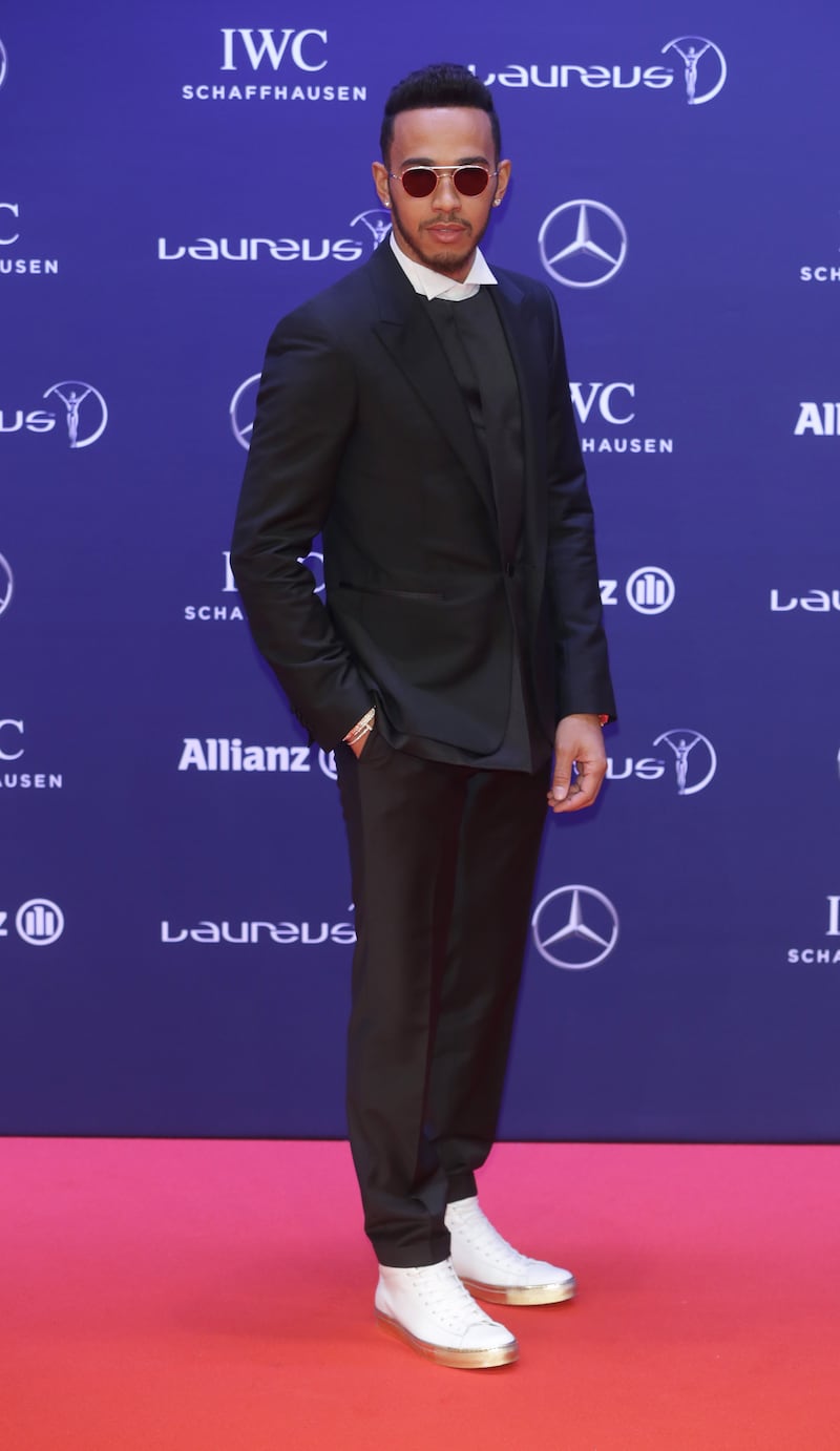 Lewis Hamilton, in a black suit over a jumper and shirt with Cartier accessories, arrives at the Laureus Sport Awards in Berlin on April 18, 2016. EPA