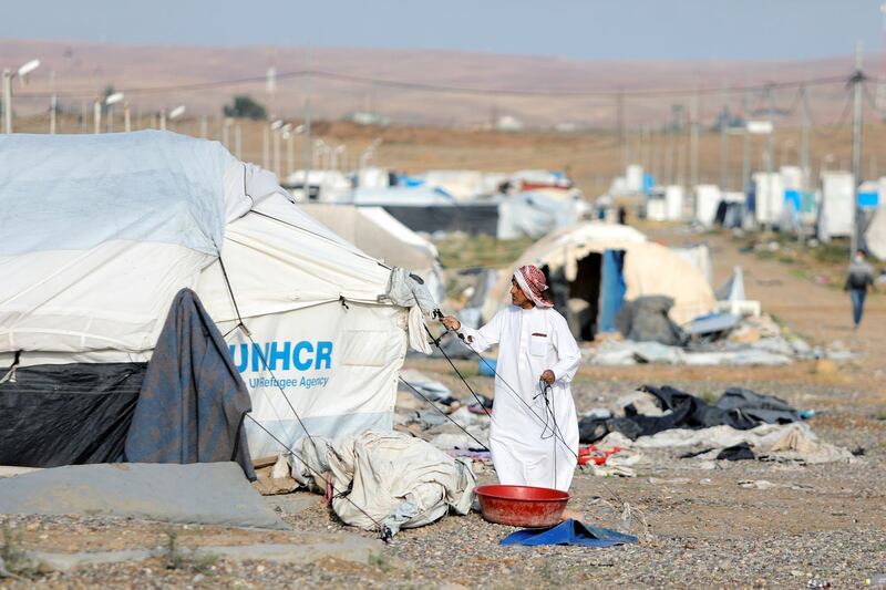 An Iraqi man dismantles his tent as he prepares to leave at Hammam Al Alil camp south of Mosul. Reuters