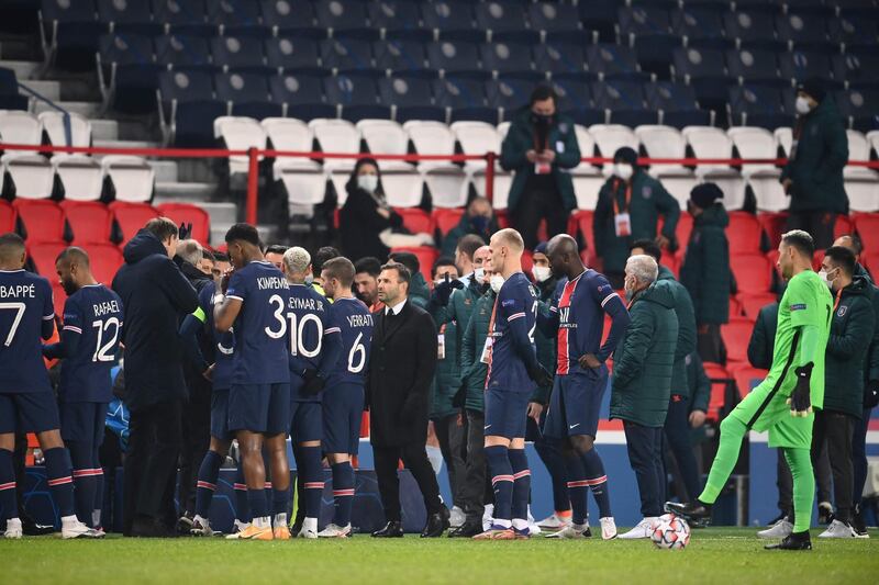 Istanbul Basaksehir coach Okan Buruk (C) stands amongst players and staff after the game was suspended amid allegations of racism by one of the match officials. AFP