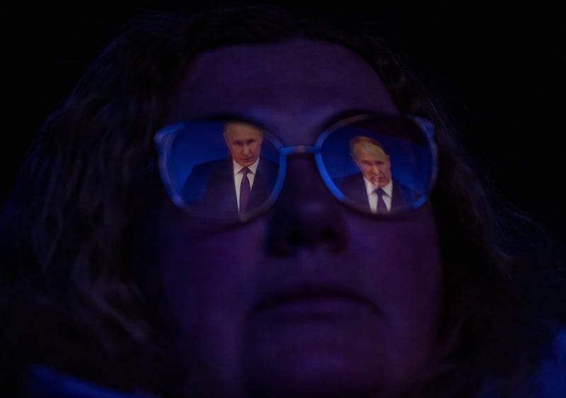 A woman watches a TV broadcast of Russian President Vladimir Putin's annual address to the Federal Assembly in a cinema in Saint Petersburg, Russia. Reuters