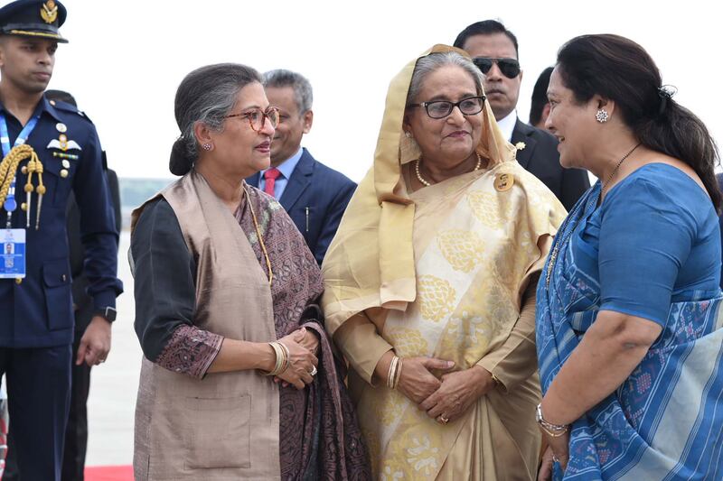 Bangladesh Prime Minister Sheikh Hasina, centre, is greeted by Indian Minister of State for Agriculture and Farmers' Welfare Shobha Karandlaje, right, on her arrival in Delhi for the G20 summit. EPA