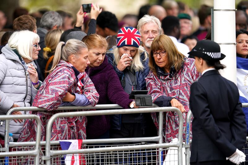 Members of the public watch the funeral from Horse Guards Road in London. PA