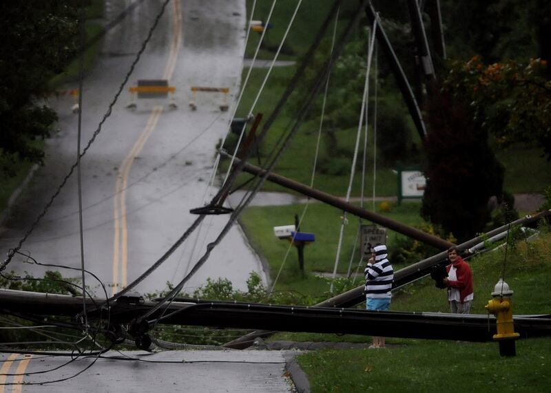Residents on Foster Street in South Windsor, Conn., look over the mess of wires and down utility poles that were brought down during Irene, the hurricane that weakened to a tropical storm, Sunday, Aug. 28, 2011. (AP Photo/Journal Inquirer, Jim Michaud)  MANDATORY CREDIT *** Local Caption ***  Irene.JPEG-07590.jpg