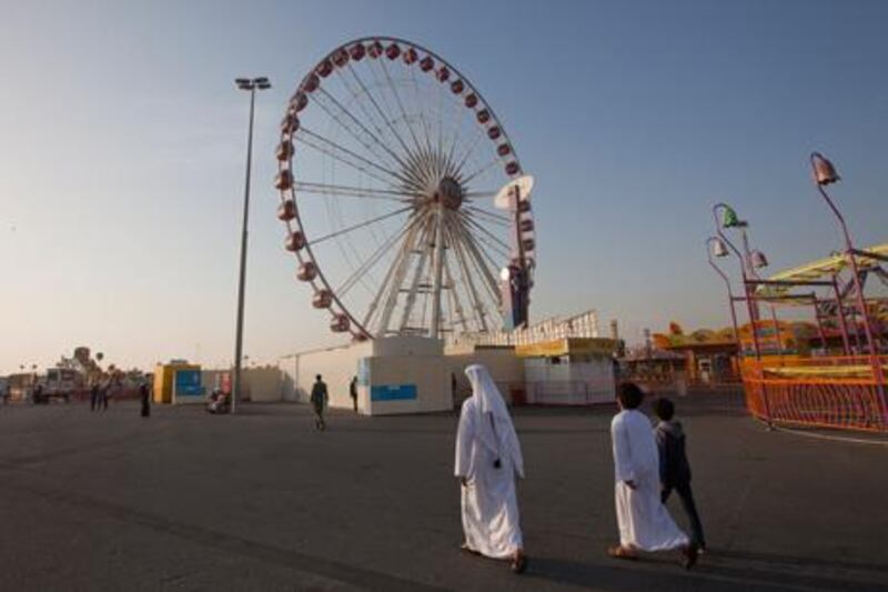 People walk near the Ferris wheel at Dubai’s Global Village where an Emirati man died last month. Jaime Puebla / The National