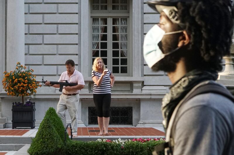 A man and woman draw their firearms on protestors as they enter their neighbourhood during a protest against St. Louis Mayor Lyda Krewson. Reuters