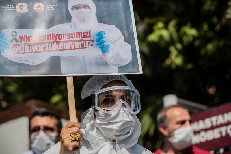 Turkish doctors hold placards reading 'you cannot manage, we are exhausted, we die' during a protest against the government in front of the Istanbul Faculty of Medicine, in Istanbul.  EPA