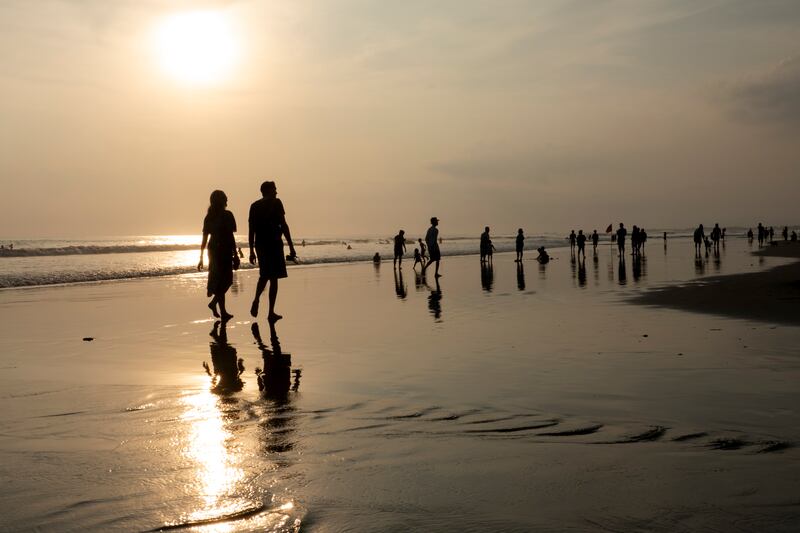 Tourists walk at a beach in Seminyak, Bali, Indonesia. Business-leisure travellers live and work abroad for longer than a typical holiday without taking up permanent residence. EPA