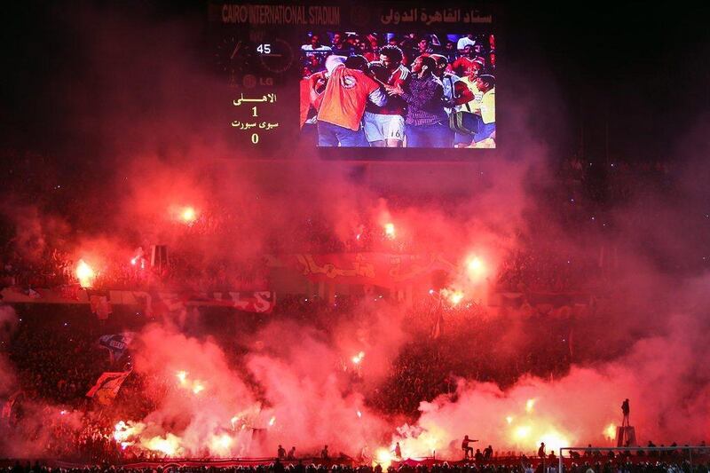 Fans of Cairo's Al Ahly light flares after the added time goal that proved the winner for the club in the CAF Confederation Cup final on Saturday. Mohamed El Shahed / AFP