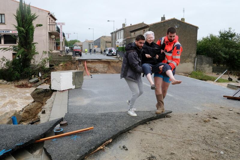 An elderly woman is carried to safety in Villegailhenc.  AFP