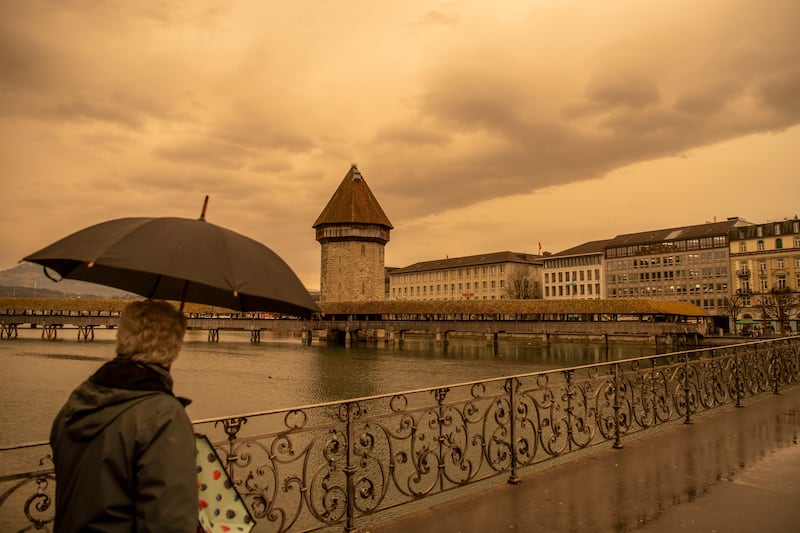 The Kapellbruecke and the Wasserturm in Lucerne appear against an orange-tinged sky in Switzerland. AP