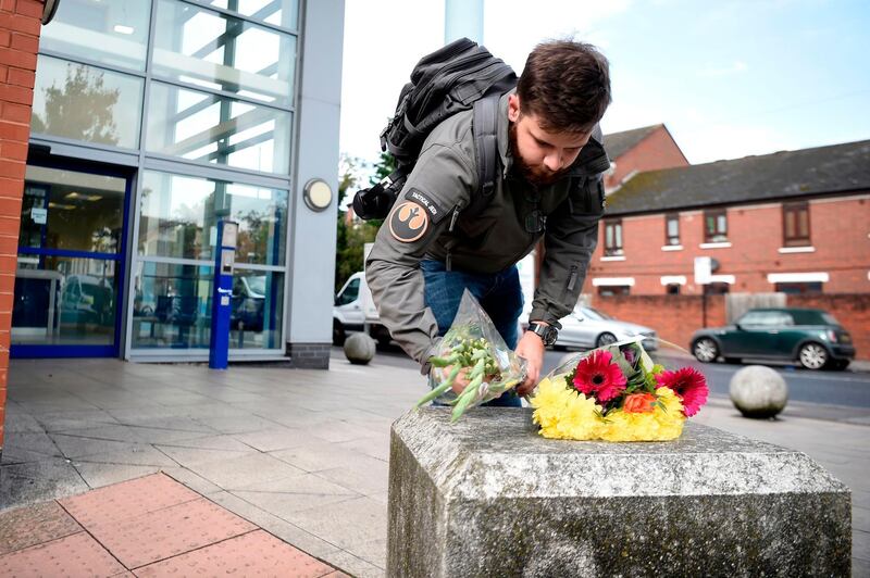 A well-wisher places flowers outside the Croydon Custody Centre in south London on September 25, 2020, following the shooting of a British police officer by a 23-year-old man being detained at the centre.  A British police officer was shot dead in the early hours of Friday morning, Scotland Yard said, the first officer to be killed by gunfire while on duty in over eight years. / AFP / DANIEL LEAL-OLIVAS
