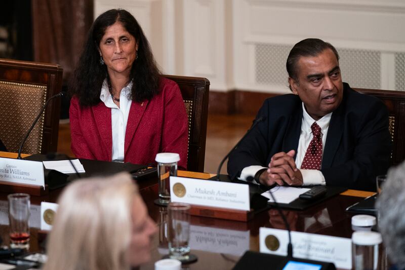 Sunita Williams, NASA astronaut, left, listens as Mukesh Ambani, Chairman and Managing Director of Reliance Industries, right, speaks during the meeting. AP Photo
