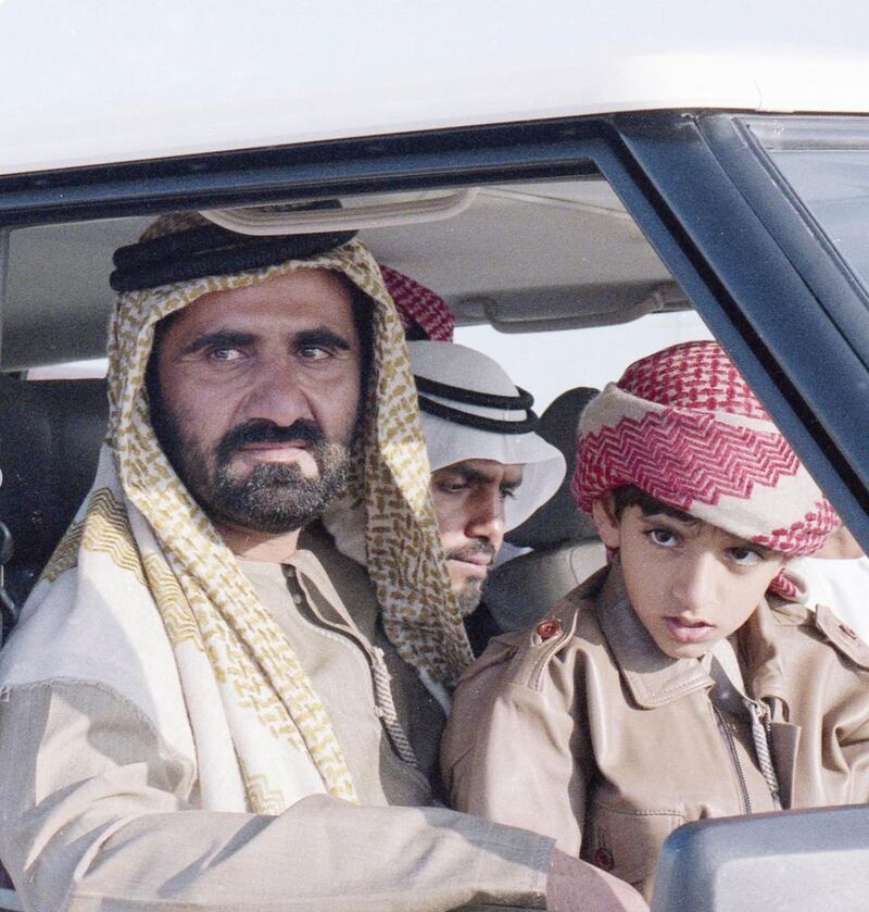 Sheikh Hamdan sits with his father in the front of a car.