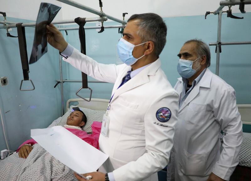 A doctor looks at an X-ray of a man who was wounded during an attack at the university of Kabul. REUTERS