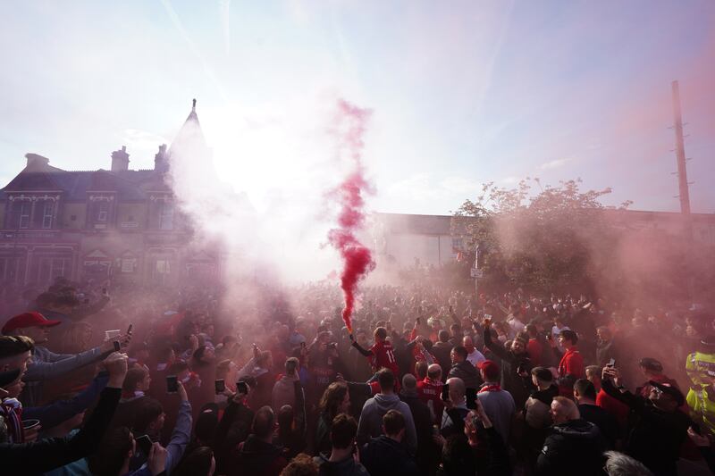 Liverpool fans greet their team bus. PA