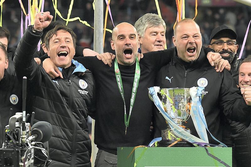 Manchester City's Spanish manager Pep Guardiola (C) celebrates with his backroom staff, Manchester City's Spanish assistant coach Rodolfo Borrell (R) as City players celebrate their win after the English League Cup final football match between Aston Villa and Manchester City at Wembley stadium in London on March 1, 2020. - Manchester City won the game 2-1. (Photo by Glyn KIRK / AFP)