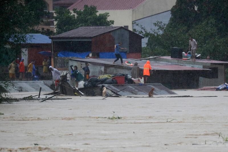 Residents trapped on their roofs prepare to evacuate as floods continue to rise in Marikina. AP Photo