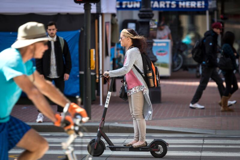 A person rides a Bird Rides Inc. shared electric scooter in San Francisco, California, U.S., on Friday, April 13, 2018. GPS-enabled scooters and bicycles are spreading across several major U.S. cities, driven by a wave of venture capital into a handful of companies. Policymakers are scrambling to find ways to regulate the great scooter boom of 2018. Photographer: David Paul Morris/Bloomberg