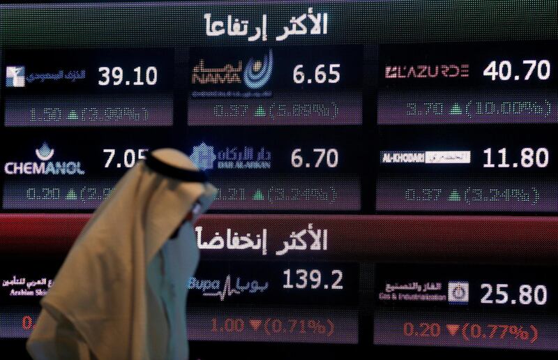 FILE PHOTO: An investor walks past a screen displaying stock information at the Saudi Stock Exchange (Tadawul) in Riyadh, Saudi Arabia June 29, 2016. REUTERS/Faisal Al Nasser/File Photo