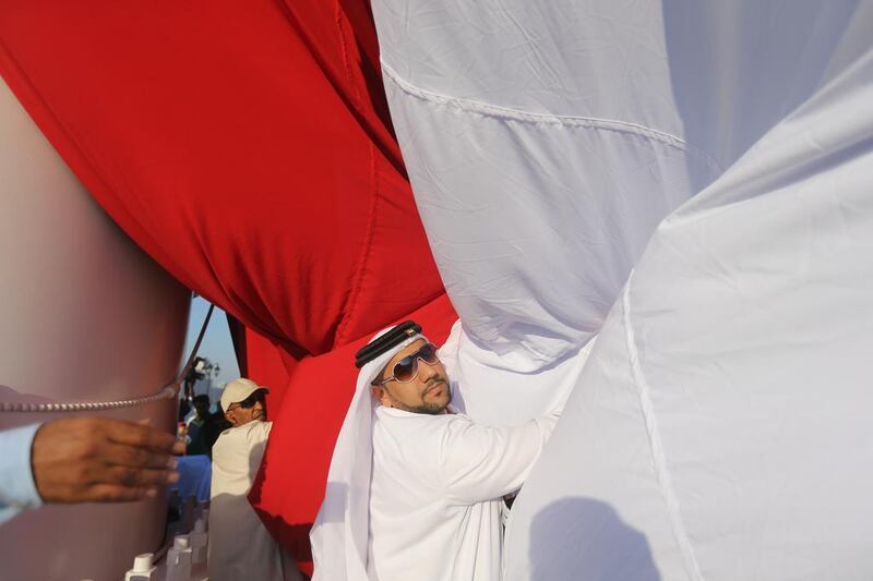 A large UAE flag being launched as Ras al Khaimah prepares to celebrate UAE's 42nd National Day. Sammy Dallal / The National