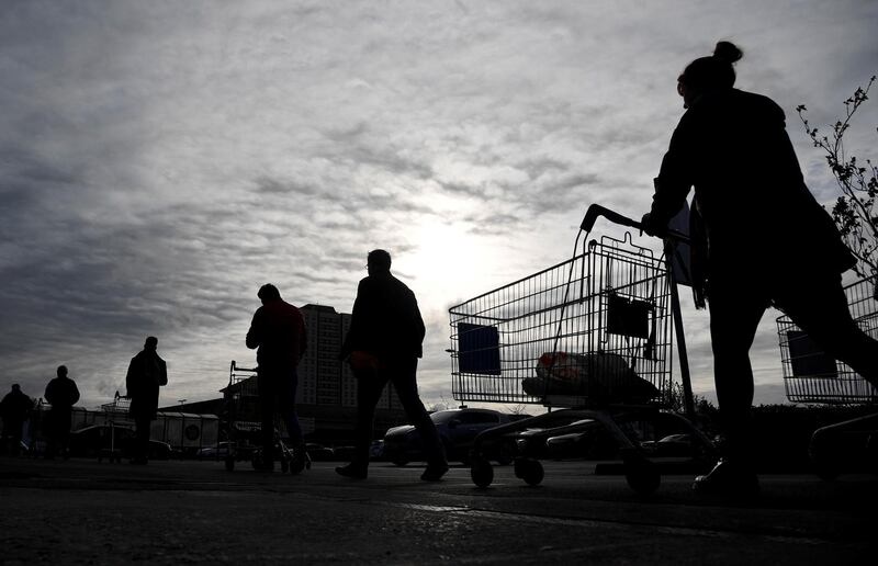 FILE PHOTO: Shoppers queue to enter a Tesco supermarket, as the spread of the coronavirus disease (COVID-19) continues, in West London, Britain, March 20, 2020. REUTERS/Toby Melville/File Photo