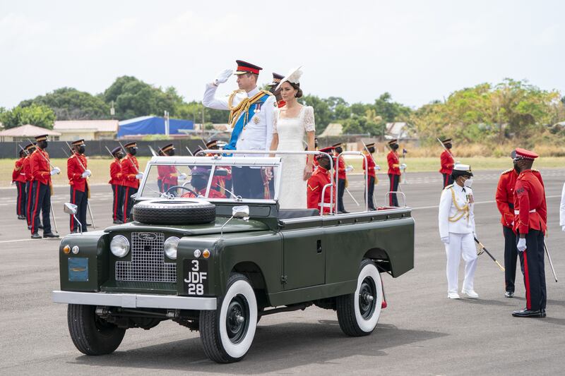 Prince William and Kate ride in a Jeep at the parade.