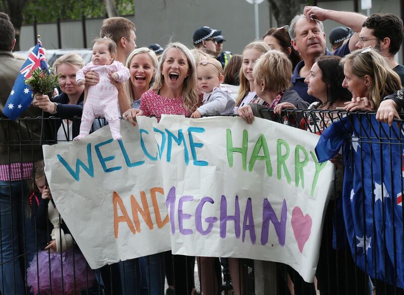 Children hold a banner as they wait for the arrival of the royal couple. EPA