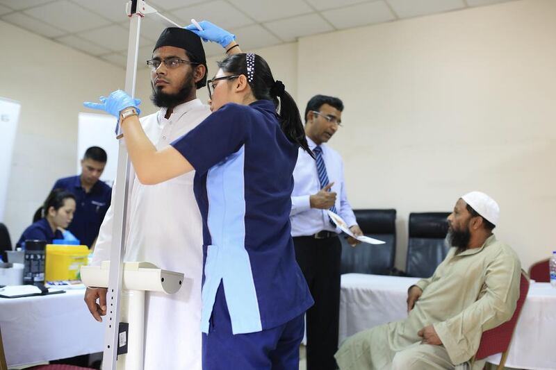 Nursing assistant Farha Mansan checks Said Imran’s height and weight at a Pakistan Association Dubai health-awareness drive. Sarah Dea / The National 