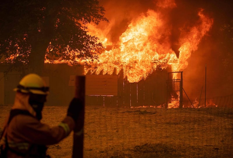 A firefighter watches as a building burns during the Mendocino Complex fire in Lakeport, California. AFP PHOTO / JOSH EDELSON