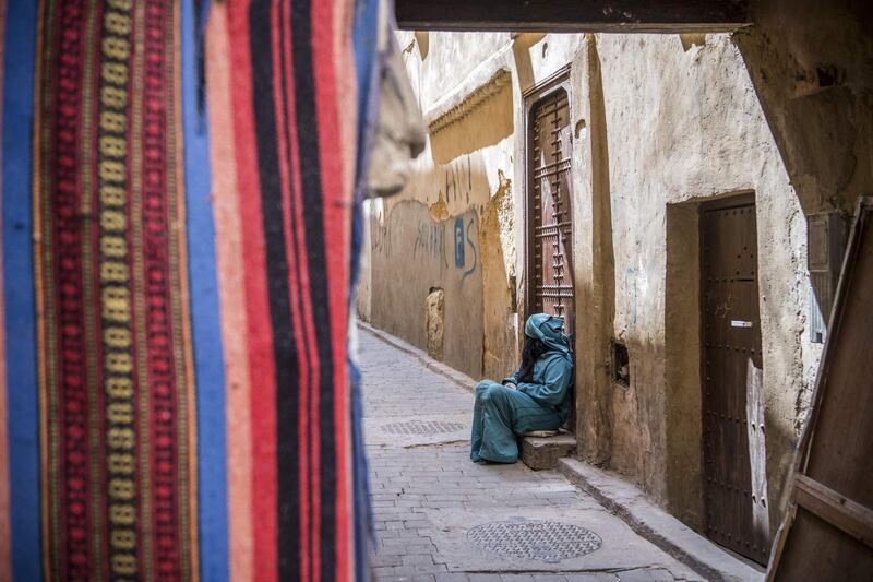 A woman sits in the 9th century walled medina in the ancient Moroccan city of Fez on April 11, 2019. AFP
