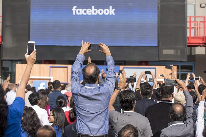 Attendees use mobile phones to take photographs of Narendra Modi, India's prime minister and Mark Zuckerberg, chief executive officer of Facebook Inc., as the arrive for a town hall meeting at Facebook headquarters in Menlo Park, California, U.S., on Sunday, Sept. 27, 2015. Prime Minister Modi plans on connecting 600,000 villages across India using fiber optic cable as part of his "dream" to expand the world's largest democracy's economy to $20 trillion. Photographer: David Paul Morris/Bloomberg