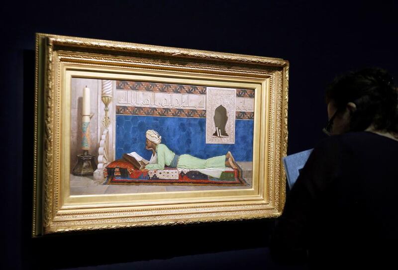 A woman looks at Osman Hamdi Bey’s 1878 painting A Young Emir Studying at the Louvre Museum in Paris in April 2014. Francois Guillot / AFP