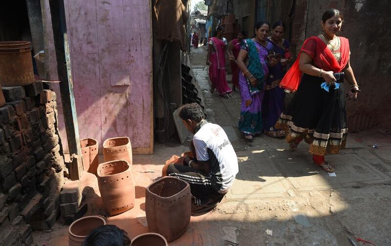A potter sanding a pot behind the "Colour Box", one of the venues of the Dharavi biennale that started on February 15. Indranil Mukherjee / AFP