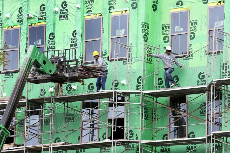 Workers unload materials from a fork lift at the site of a apartment building under construction in Orlando, Florida. The US commerce department said that construction spending increased just 0.2 per cent in March after having fallen 0.2 per cent in February. John Raoux / AP Photo