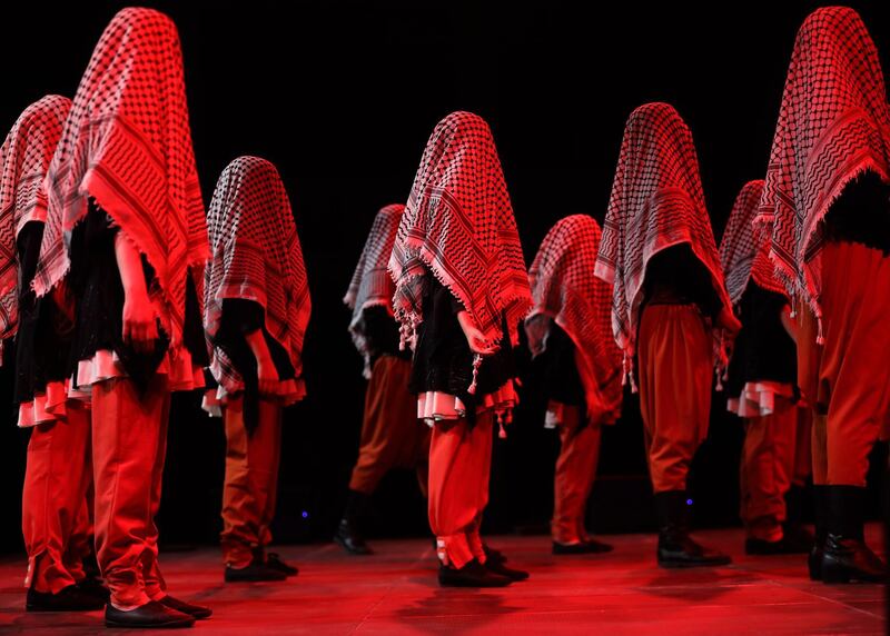 Palestinian dancers wearing traditional clothes perform a traditional folk dance on stage during Palestine International Festival 2019 in the West Bank city of Jenin. EPA