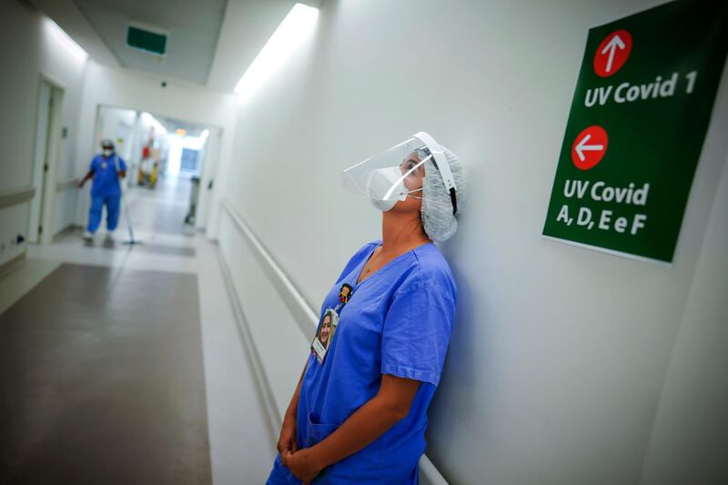 A health worker pauses in the ICU unit for Covid-19 patients at the Hospital das Clinicas in Porto Alegre, Brazil. AP Photo
