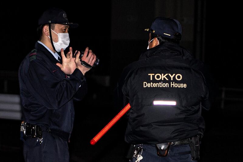 This picture taken in Tokyo on March 2, 2021 shows detention center personnel waiting for the arrival of a bus transporting former US special forces member Michael Taylor and his son Peter, who allegedly staged the operation to help fly former Nissan chief Carlos Ghosn out of Japan in 2019, in Tokyo. (Photo by Charly TRIBALLEAU / AFP)