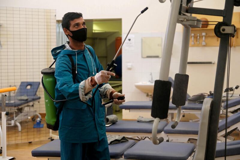 An employee from a disinfection service company wears a protective mask while sanitising sports equipment at the gym of Benghazi Medical Centre, in Benghazi, Libya. Reuters