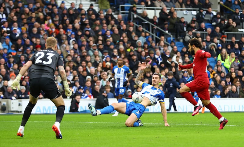 Lewis Dunk in action with Liverpool's Mohamed Salah. Action Images