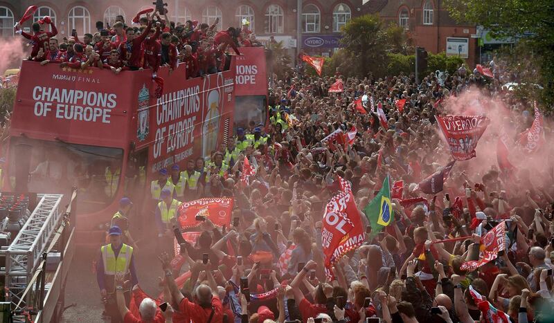 Football fans line the streets as the Liverpool football team take part in an open-top bus parade. AFP