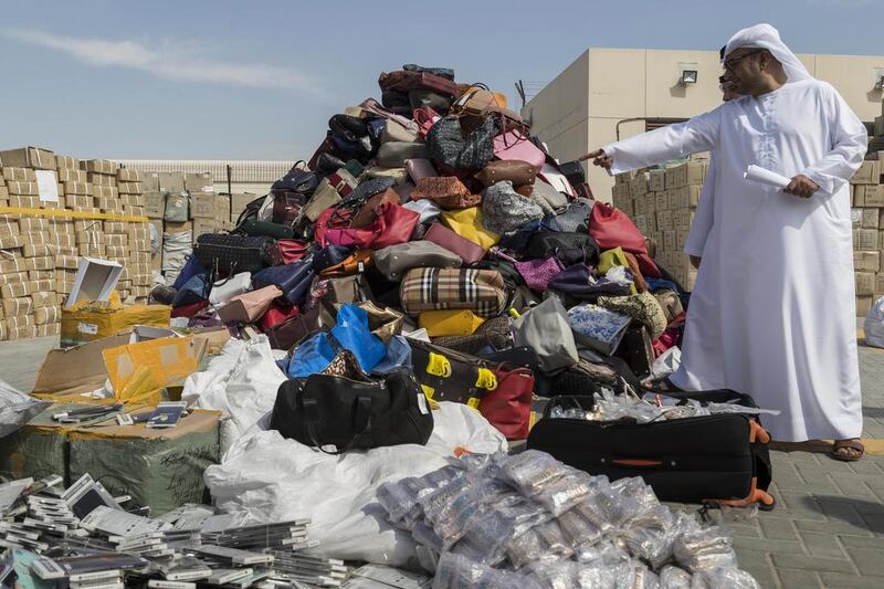 Ibrahim Behzad, director of intellectual property rights management for Dubai’s Department of Economic Development, inspects seized counterfeit products in Al Garhoud. The products are destroyed and recycled. Antonie Robertson / The National
