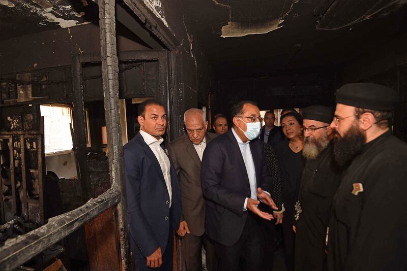 Mostafa Madbouly speaks to officials at the blaze site. AFP