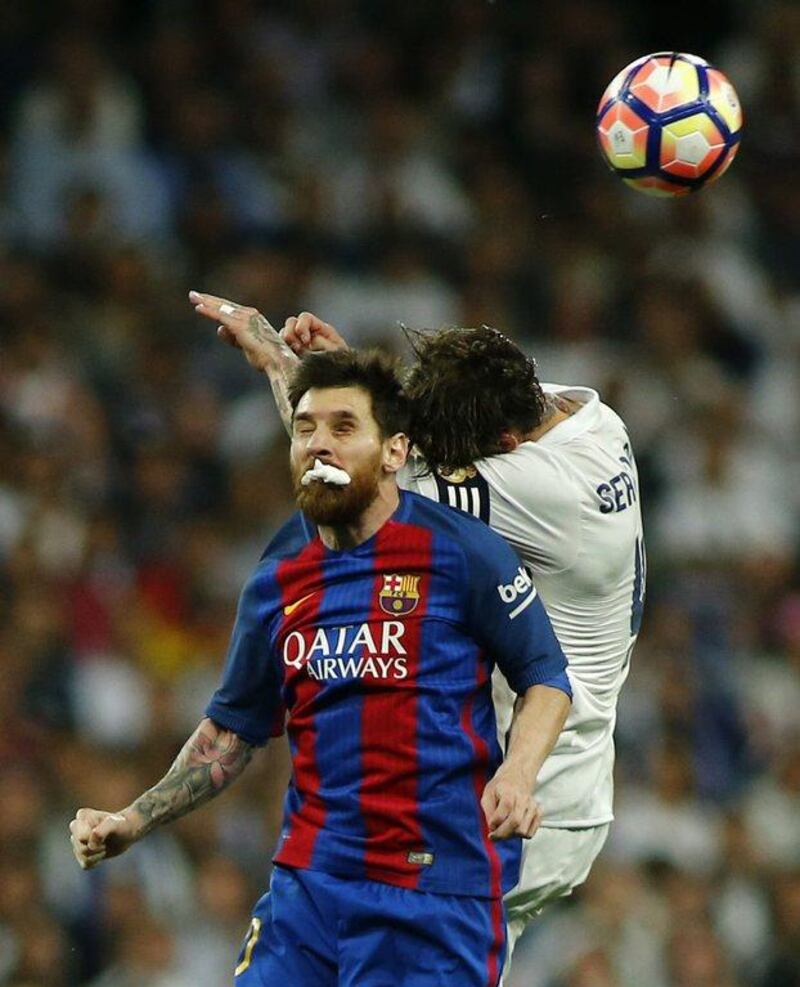 Messi bites a dressing after being injured in a jump for the ball with Ramos. Oscar Del Pozo / AFP